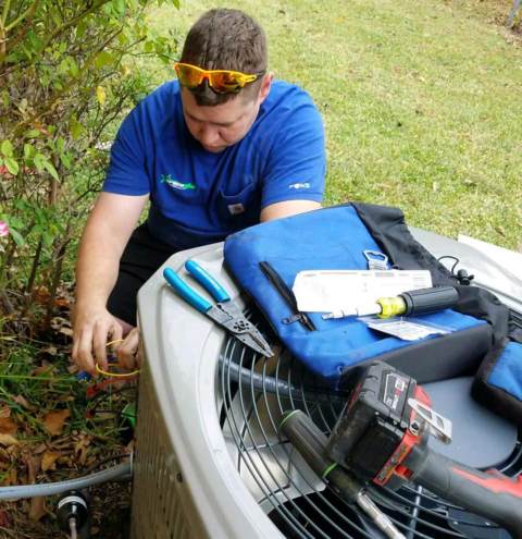 Greenstar Heating & Air technician repairs an air conditioner in Royse City TX